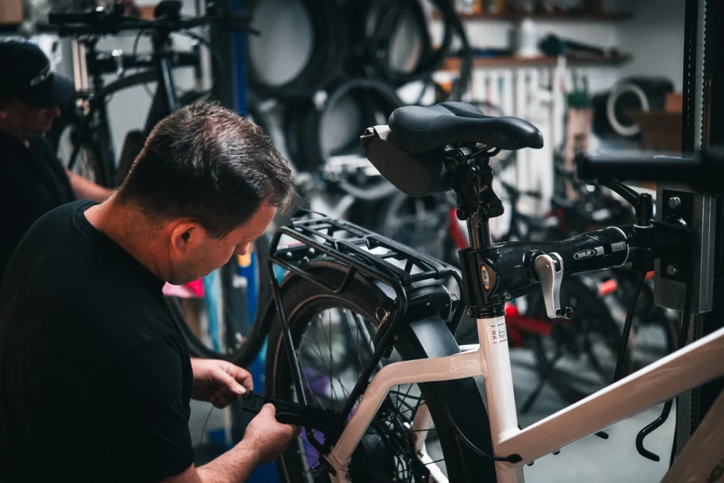 Fahrradmechaniker bei Arbeiten am Gepäckträger